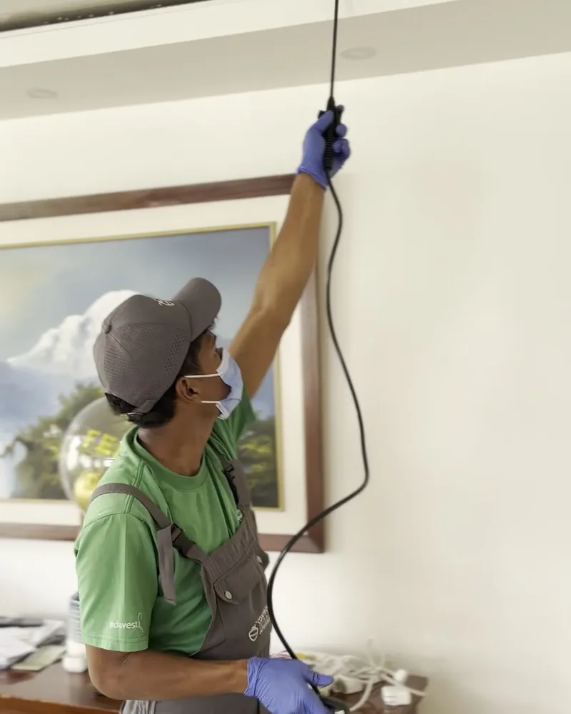 Técnico de CPI aplicando tratamiento en la sala de un hogar